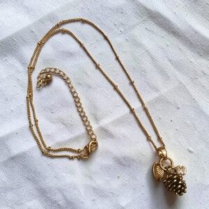Gold-toned necklace with a multi-charm pendant, pinecone, leaf & rhinestones 10"